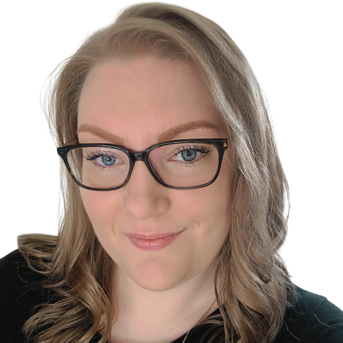 A headshot photo of Becki Wood, founder of Pyjama Shark Marketing. Becki has pale skin, blue eyes and curly light brown hair. She wears glasses and is smiling.